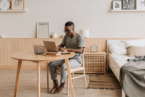 a man sitting at a table using a laptop